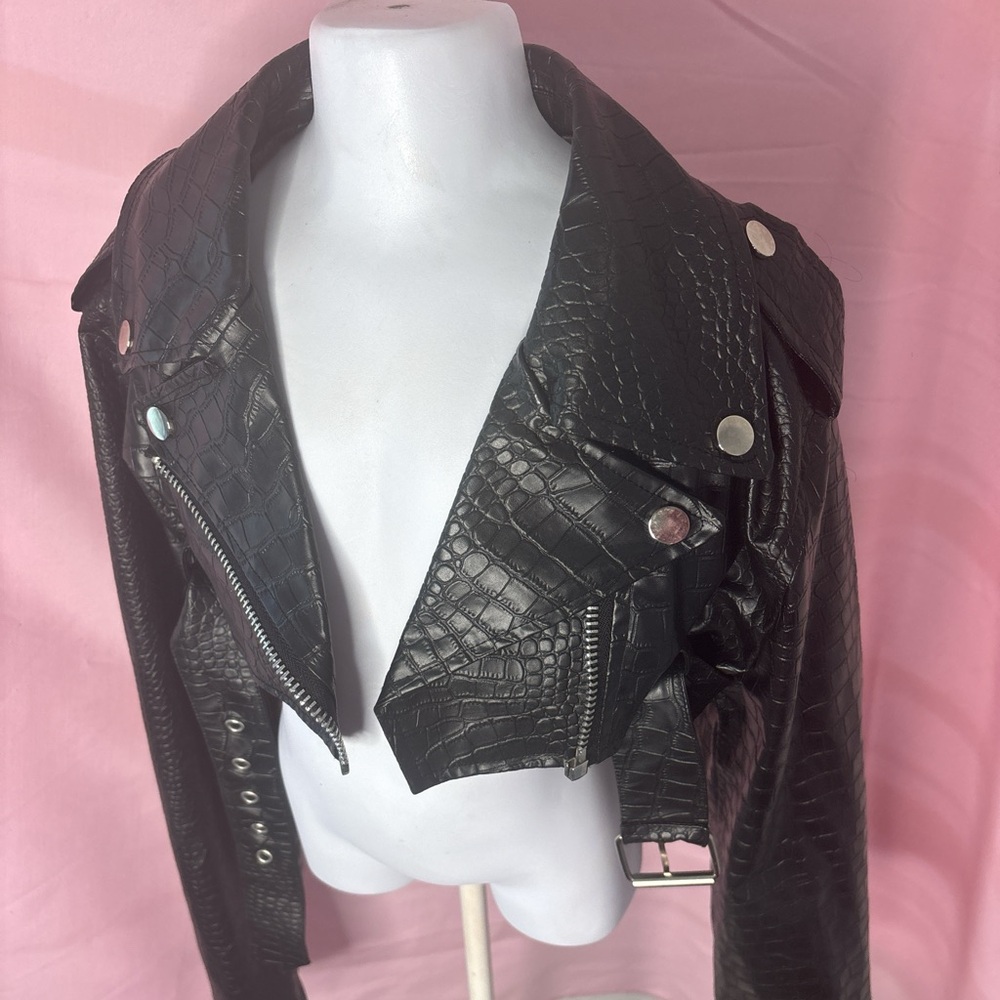 Black faux leather cropped jacket with snap button closure, zipper pockets,